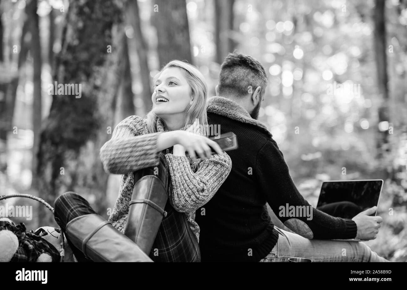 Online life modern technology. Logout of all accounts. Modern life. Happy loving couple relaxing in park with mobile gadgets. Internet addiction. Modern people always involved online communication. Stock Photo