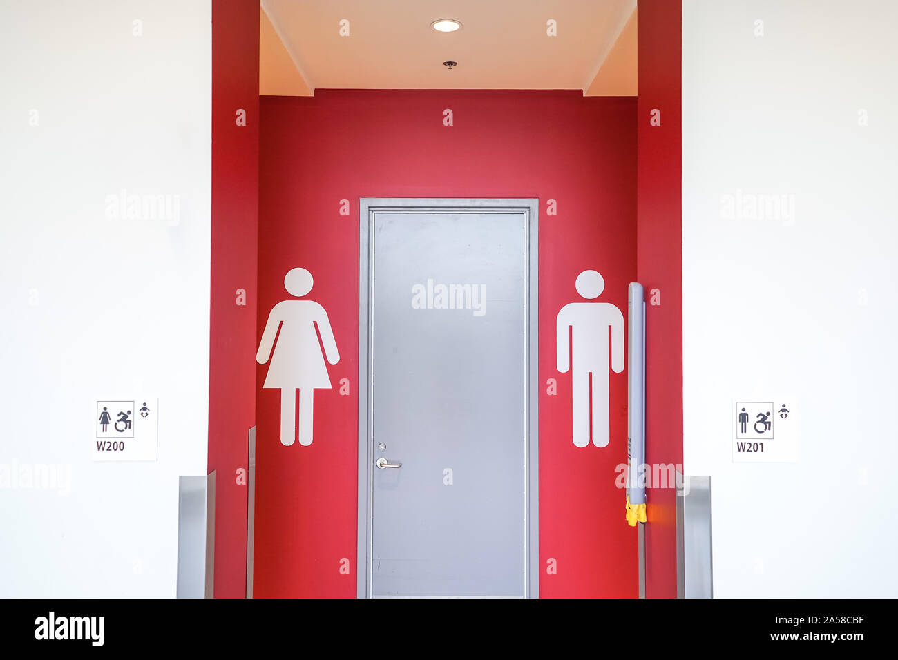 man and woman bathroom sign on bright red wall Stock Photo