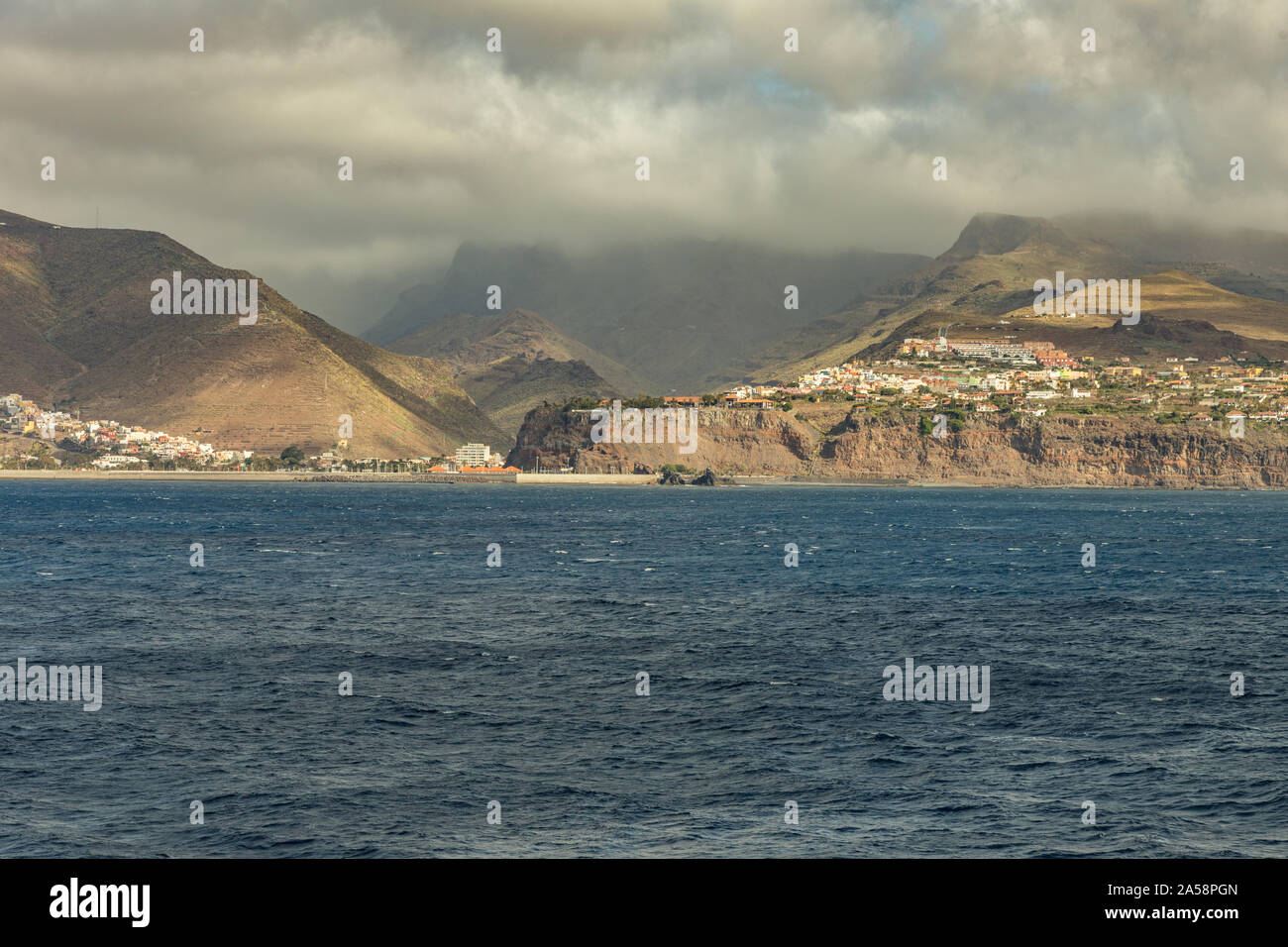 Port and town San Sebastian - capital of La Gomera Island. View from the ferry cruising between the islands of Tenerife and La Gomera. Canary Islands, Stock Photo