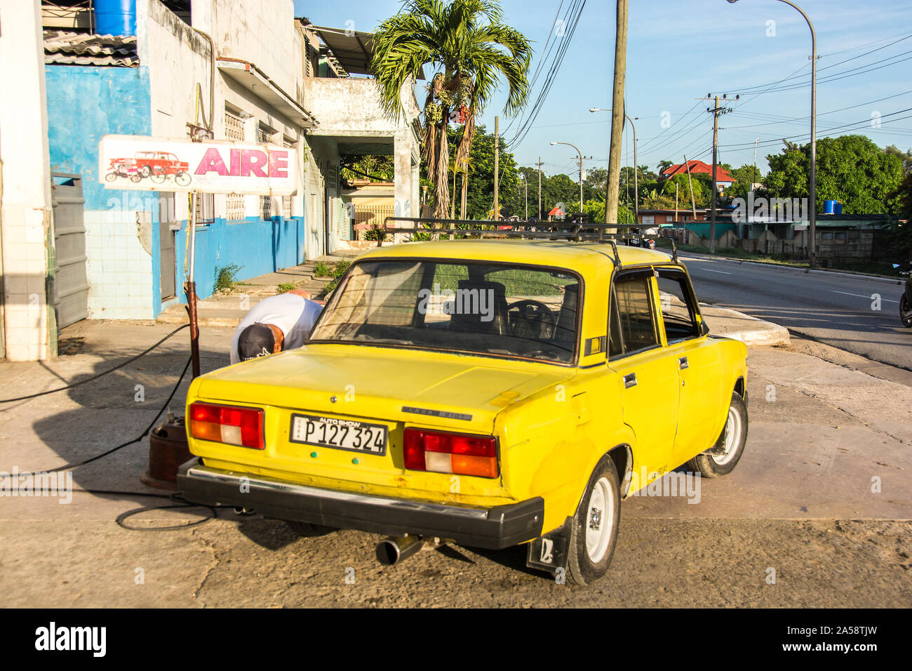 A person filling up his car with gas at a Cuban gas station; Camaguey, Cuba Stock Photo