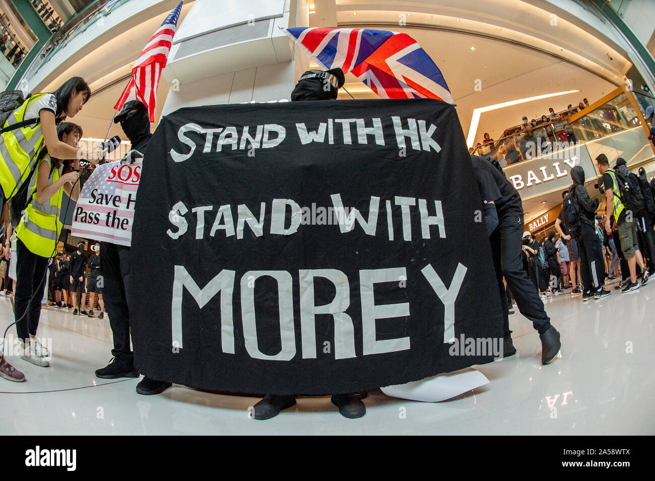 Hong Kong protestors wave British and American flags in protest in a shopping mall in Hong Kong before violence erupts Stock Photo