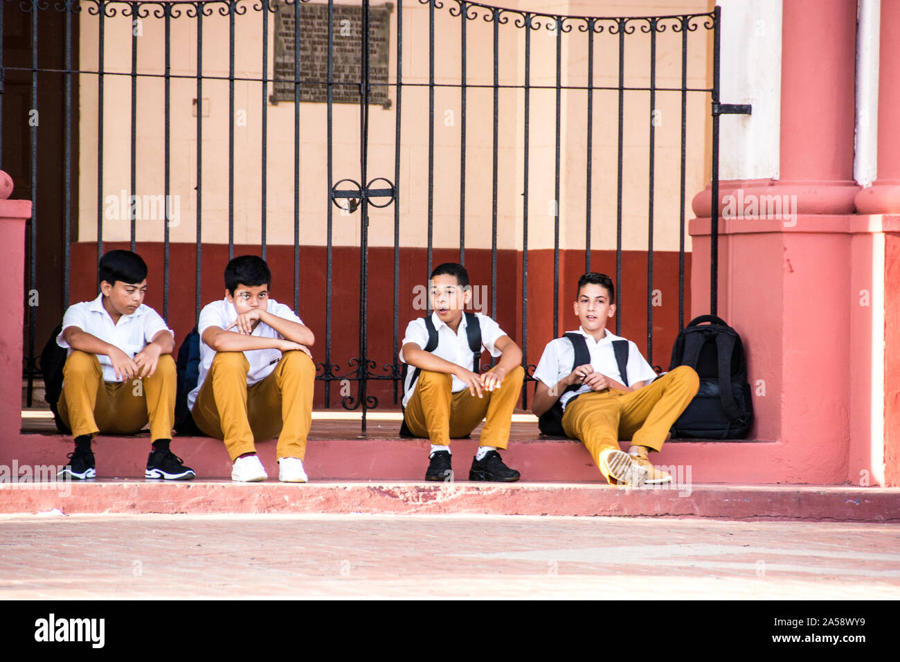 A group of Junior High students in front of a church relaxing after the conclusion of school; Camaguey, Cuba Stock Photo