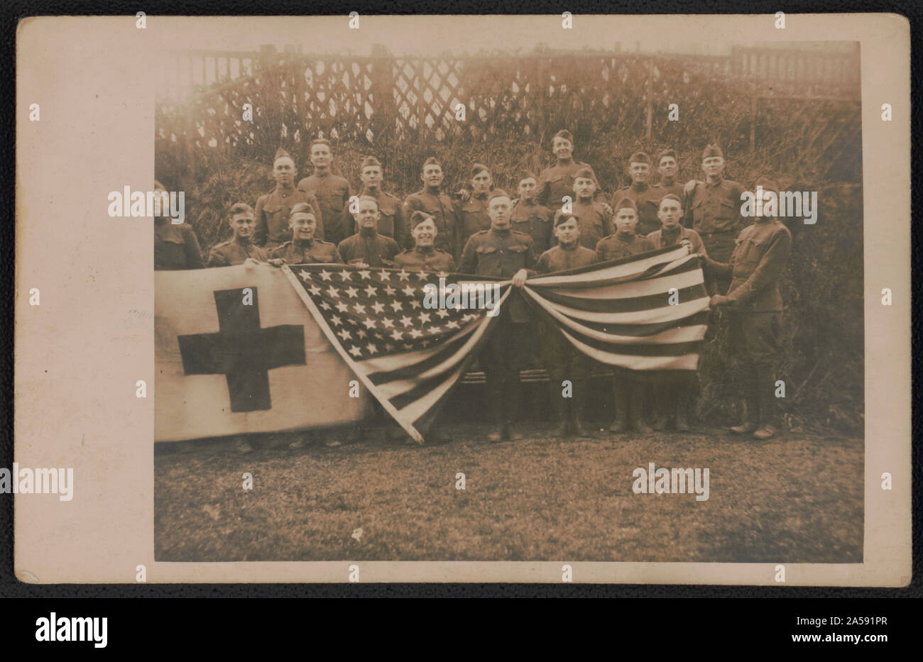 Unidentified soldiers of Army medical company in uniform with American flag and red cross banner Stock Photo