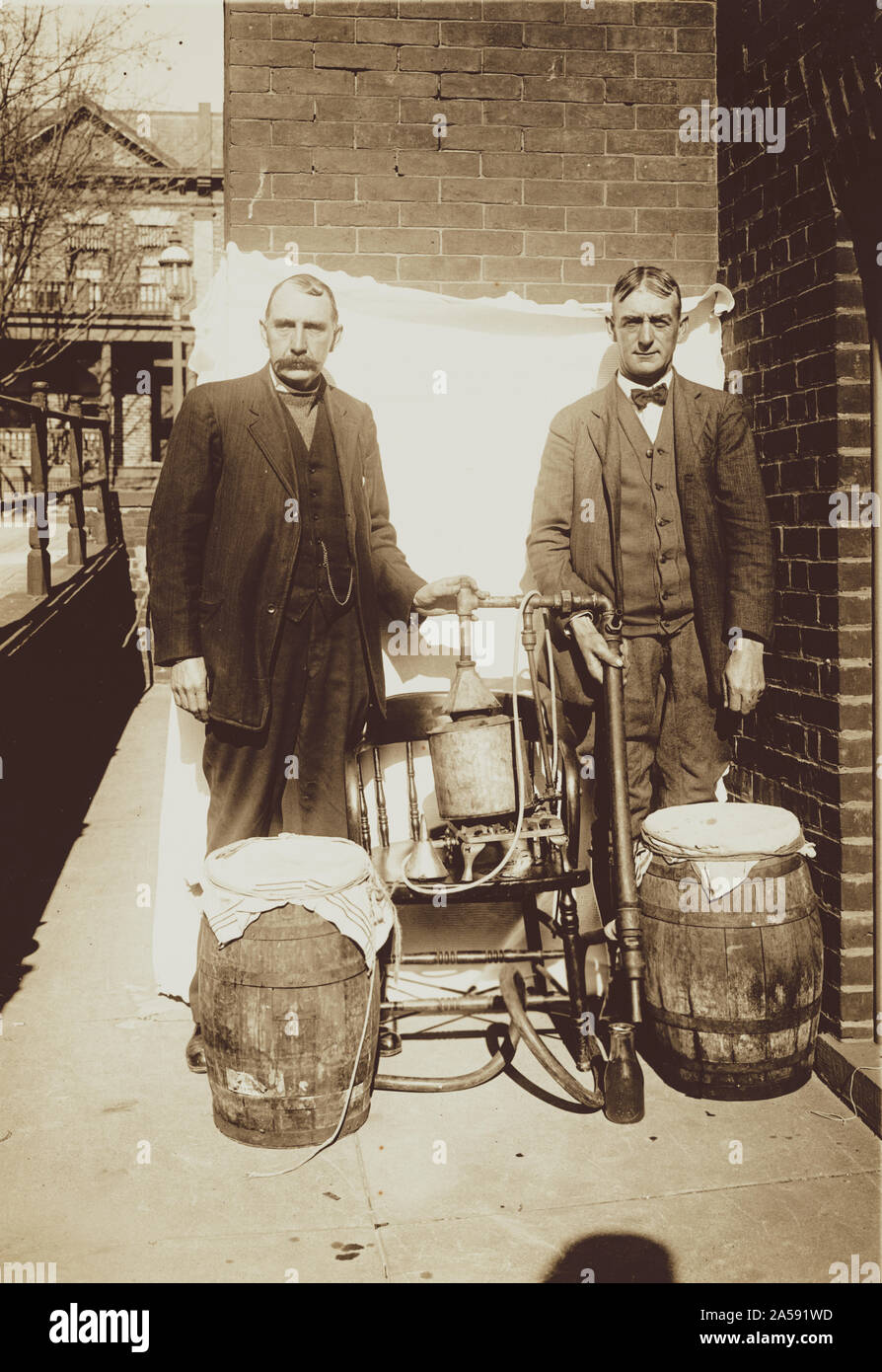 Prohibition still. Two federal agents stand with a confiscated bootleggers still. Stock Photo