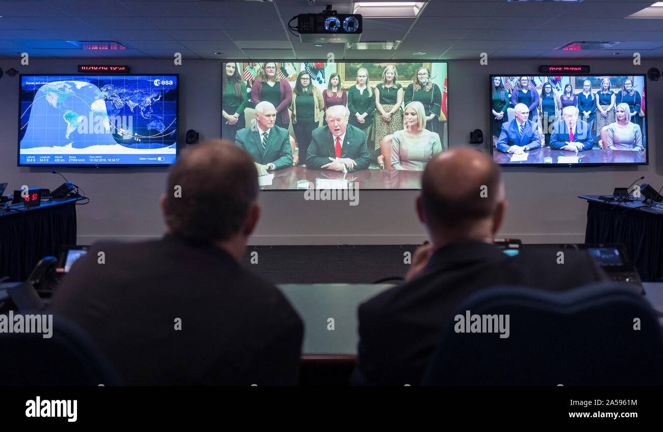 Washington, United States of America. 18 October, 2019. NASA Deputy Administrator Jim Morhard and International Space Station Director Sam Scimemi, watch a video monitor at the Space Operations Center as U.S. President Donald Trump speaks to astronauts Christina Koch and Jessica Meir by video-link prior to their all-woman spacewalk October 18, 2019 in Washington, DC. Sitting with the president is Vice President Mike Pence, left, and presidential daughter Ivanka Trump. Credit: Joel Kowsky/NASA/Alamy Live News Stock Photo