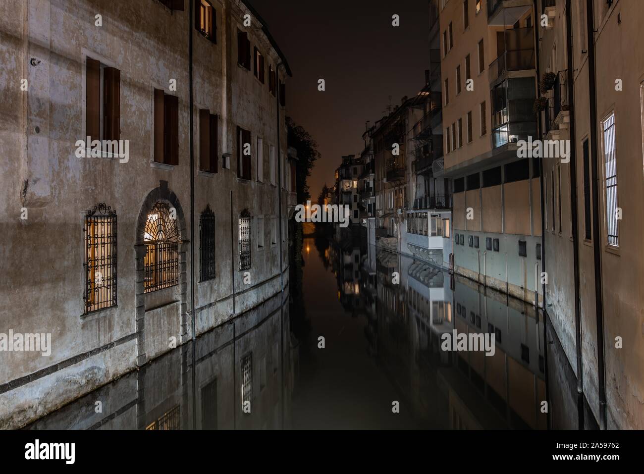 Horizontal shot of a canal between apartment buildings at night time in