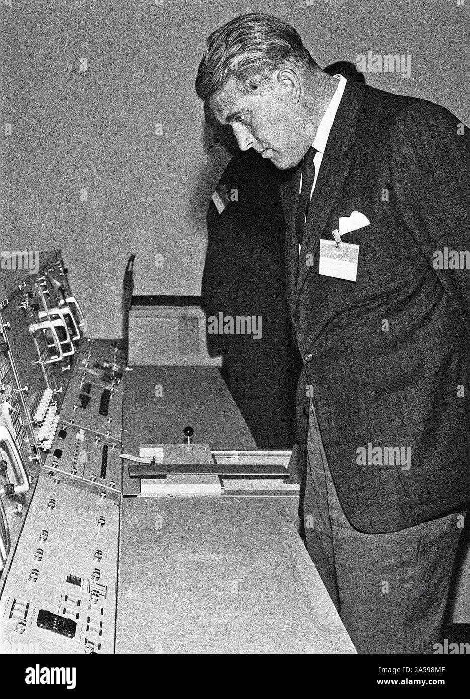 This photograph, dated October 14, 1964, was taken at the Marned Spacecraft Center, now the Johnson Space Center in Houston, Texas. Dr. von Braun is shown looking over consoles in the Manned Spaceflight Control Center. Stock Photo