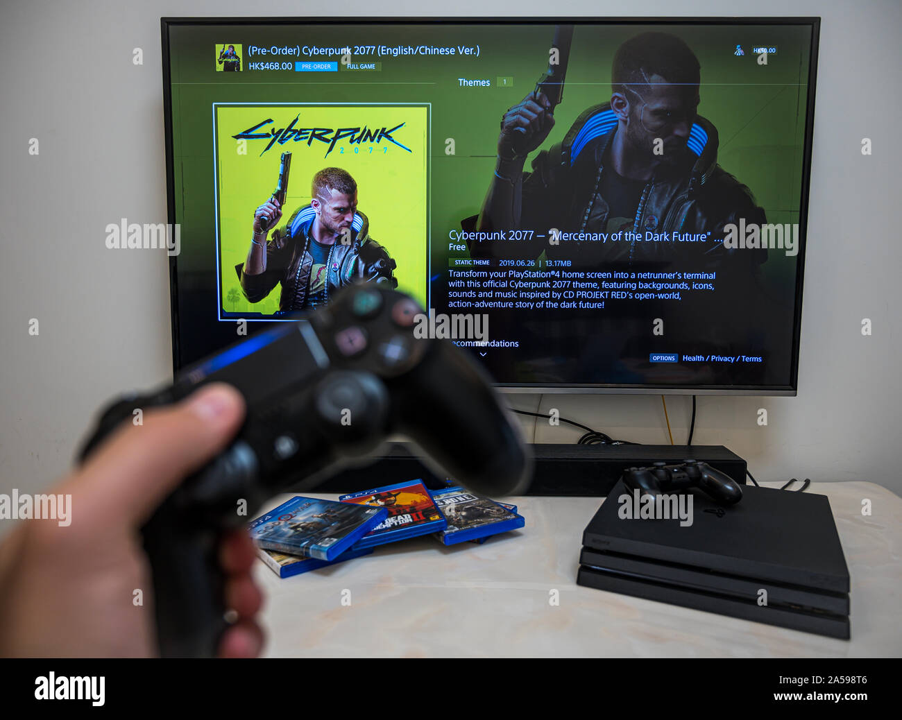 Pre-order, download, play Sony Play Station 4 Pro game Cyberpunk 2077 on  the big LCD screen at home. Controller in the hand Stock Photo - Alamy