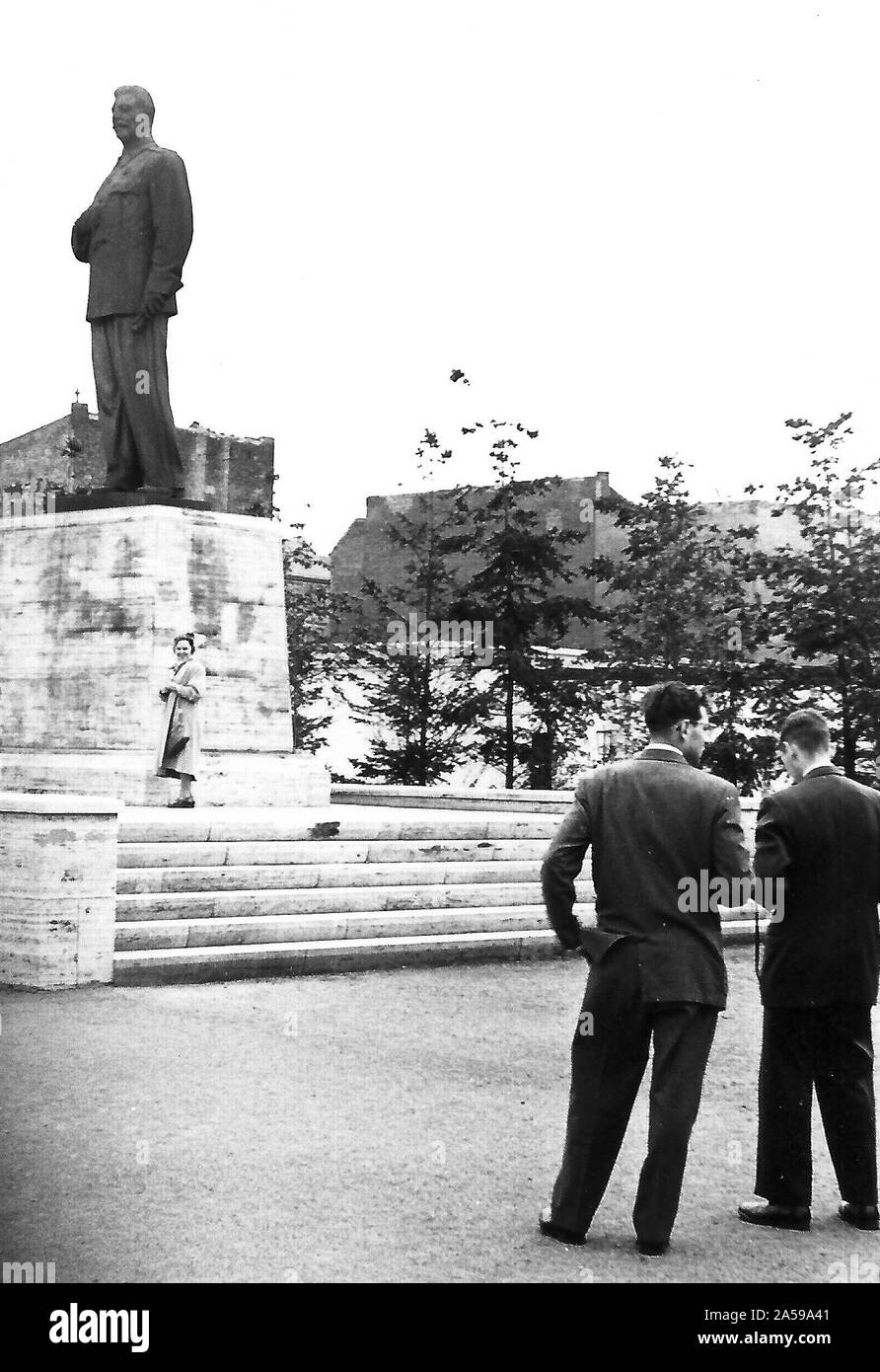 Photograph of two men and a woman in front of the former statue of Joseph Stalin on what is now Karl Marx Allee in Berlin, taken in 1955 (statue removed in 1961?) Stock Photo