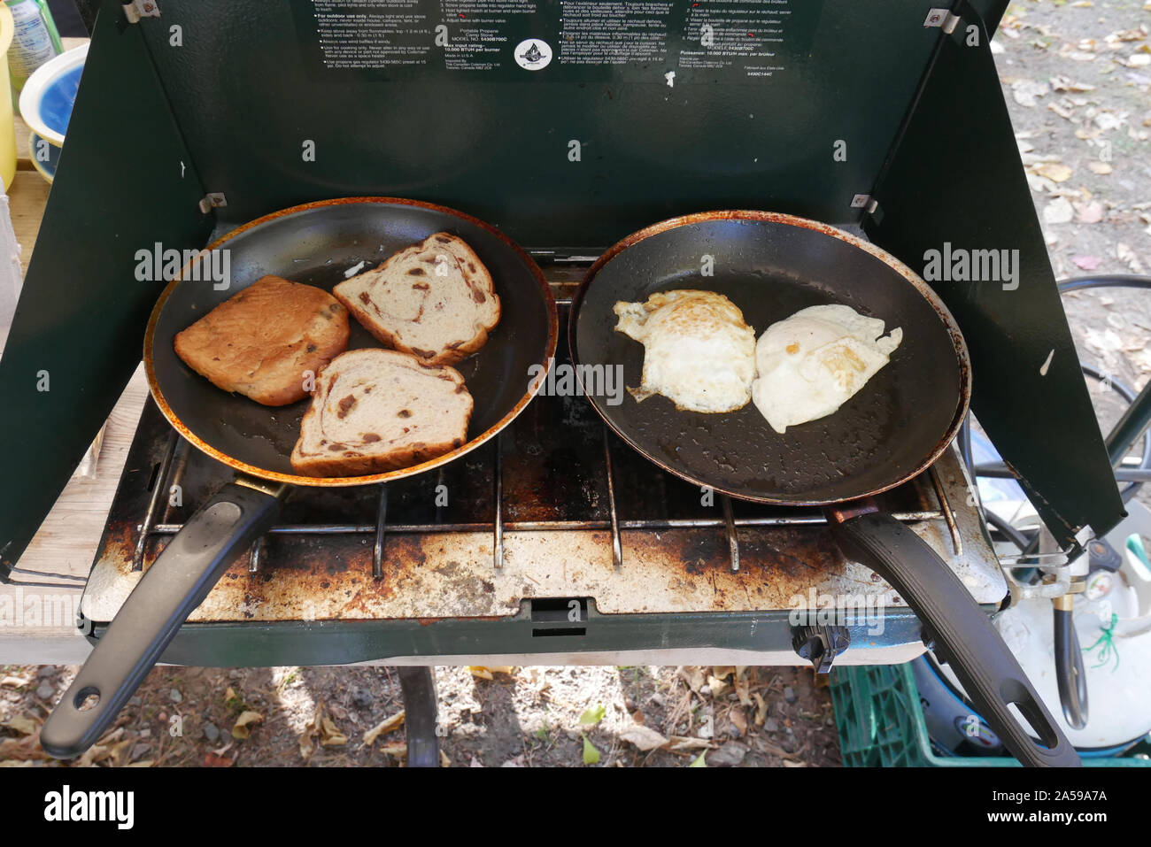 flying eggs and making toast using a propane stove outdoor Stock Photo