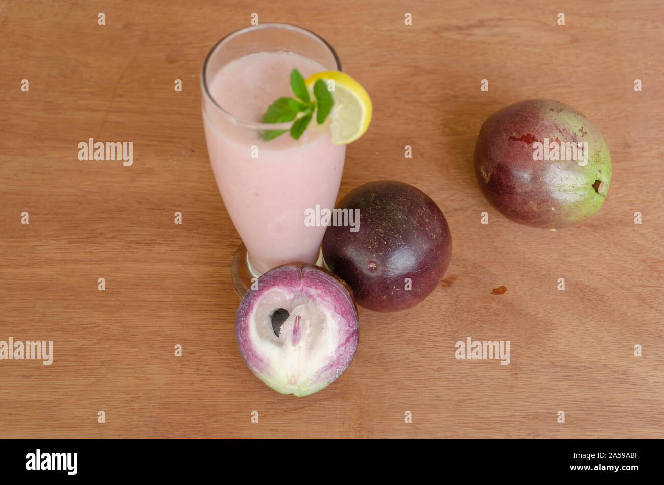 Glass Of Star Apple Juice On Wooden Table Stock Photo