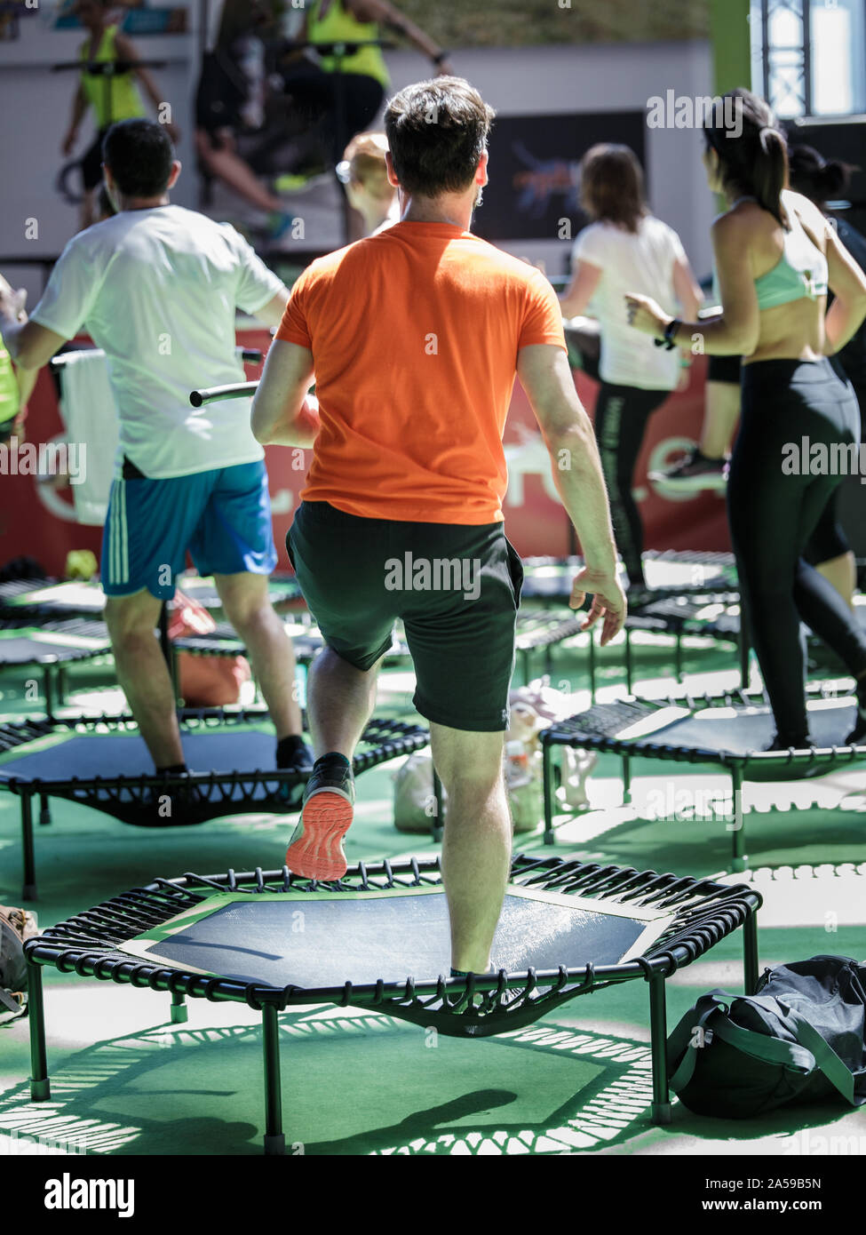 Mini Rebounder Workout - People doing Fitness Exercise in Class at Gym with  Music and Teacher on Stage Stock Photo - Alamy