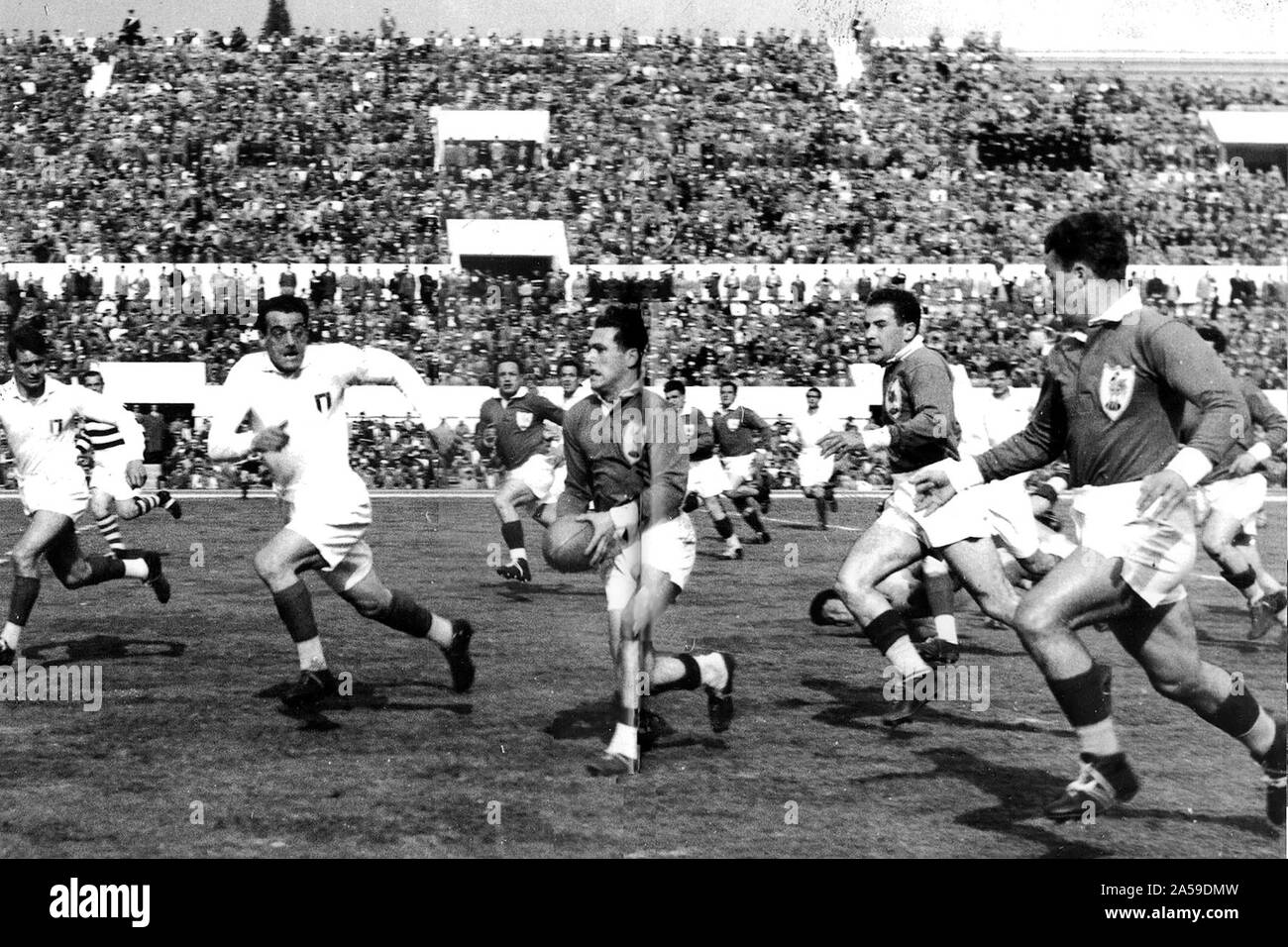 1954 Rugby union European Cup final between Italy and France at the Stadium of the 100 000 (now Stadio Olimpico) in Rome. France won the match 39-12. In this picture Frenchman Roger Martine keeps the ball assisted by his teammmates Maurice Prat et Gérard Murillo. Italian Paolo Rosi (left) e Pietro Stivano attempt to block the French attack. Stock Photo