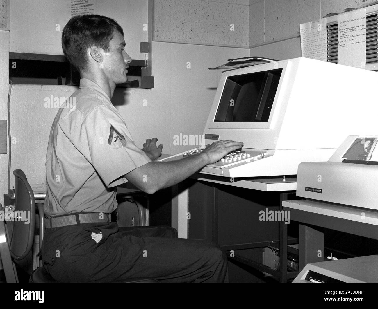 1979 - LCPL H.D. Sulger of the base communications center is processing a message on a Univac optical character reader so that the message can be transmitted to another military base. Stock Photo
