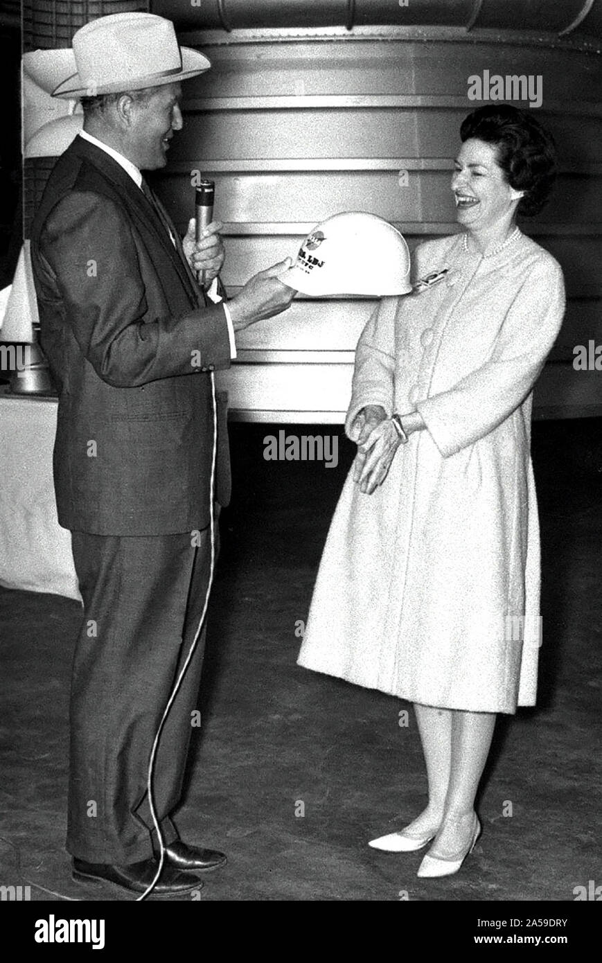 Marshall Space Flight Center Director Dr. Wernher von Braun presents Lady Bird Johnson with an inscribed hard hat during the First Lady's March 24, 1964 visit. Stock Photo
