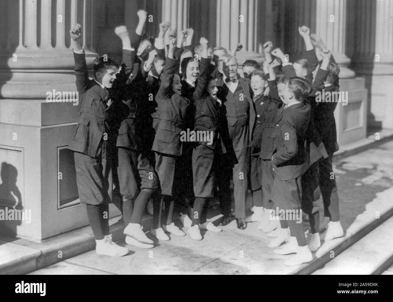 Vice President Thomas R. Marshall receiving a hearty cheer from Senate pages after he invited them to a Christmas dinner, standing on U.S. Capitol steps ca. 1913-1921 Stock Photo