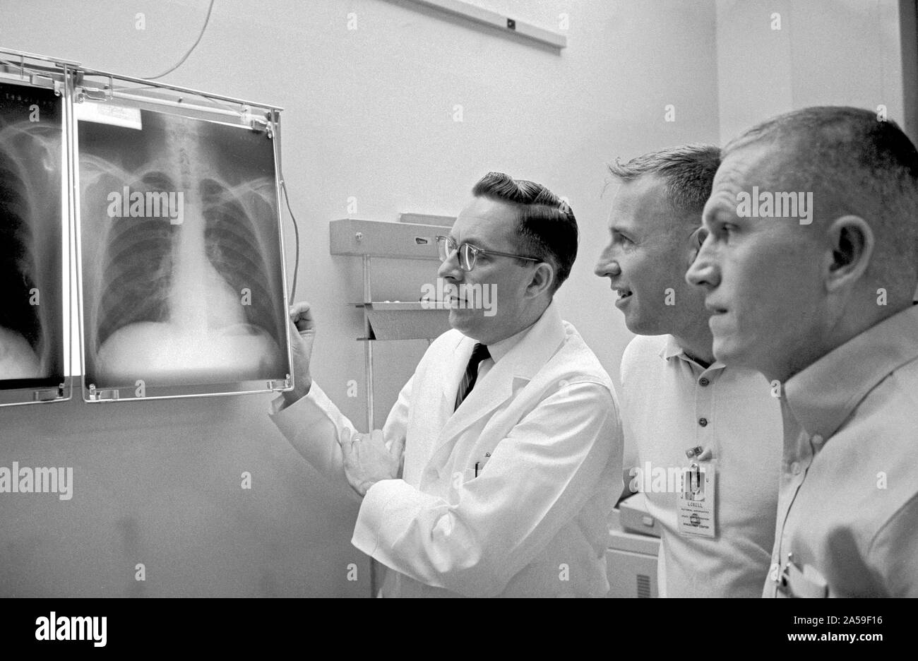 (2 Dec. 1965) --- Dr. Charles A. Berry (left), chief of the Manned Spacecraft Center (MSC) Medical Programs, and astronauts James A. Lovell Jr. (center), Gemini-7 pilot, and Frank Borman, Gemini-7 command pilot, examine a series of chest x-rays taken during the preflight physical. Stock Photo