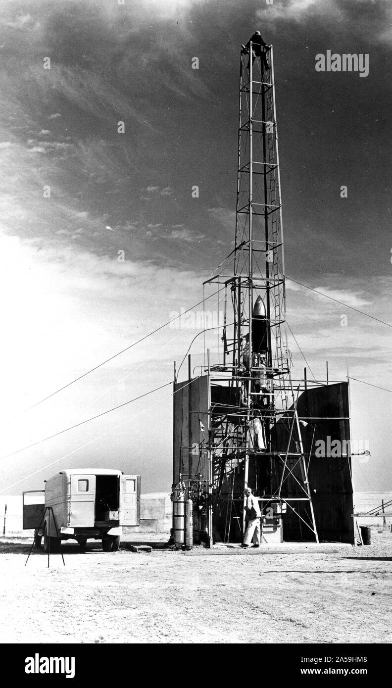 Dr. Robert Goddard's 22 foot rocket in it's launching tower, 1940, near Roswell, New Mexico. N.T. Ljungquist on the ground, A.W. Kisk working on rocket and C. Mansur at top of tower. Stock Photo