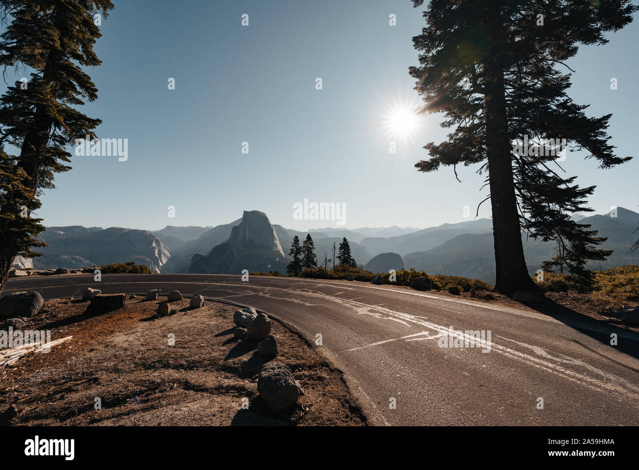 Beautiful curvy road down to Yosemite Valley with view to Half Dome Mountain Stock Photo