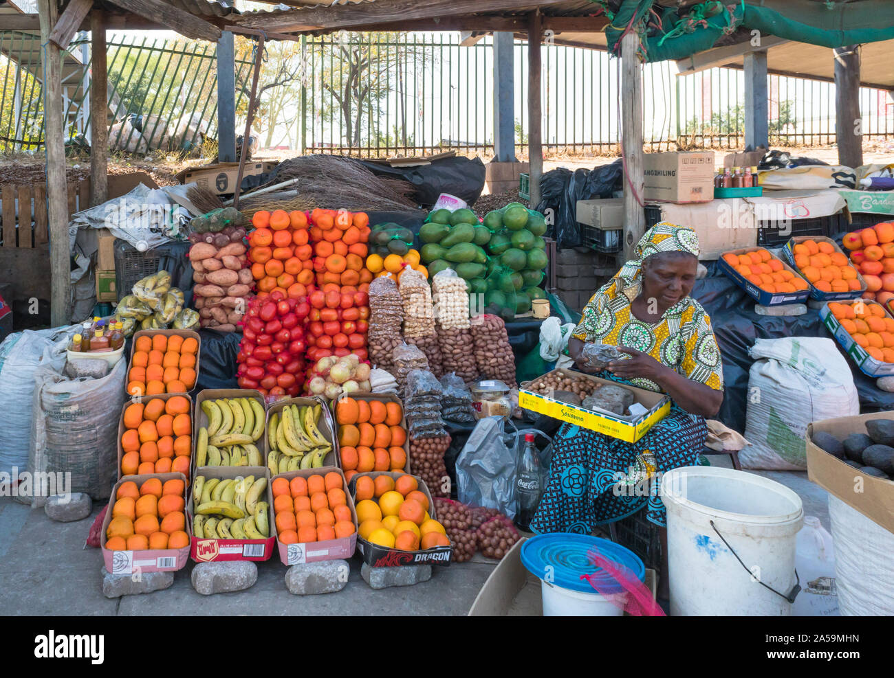 woman selling fruits, trader, vendor at a street market stall in Hazyview, Mpumalanga, South Africa Stock Photo