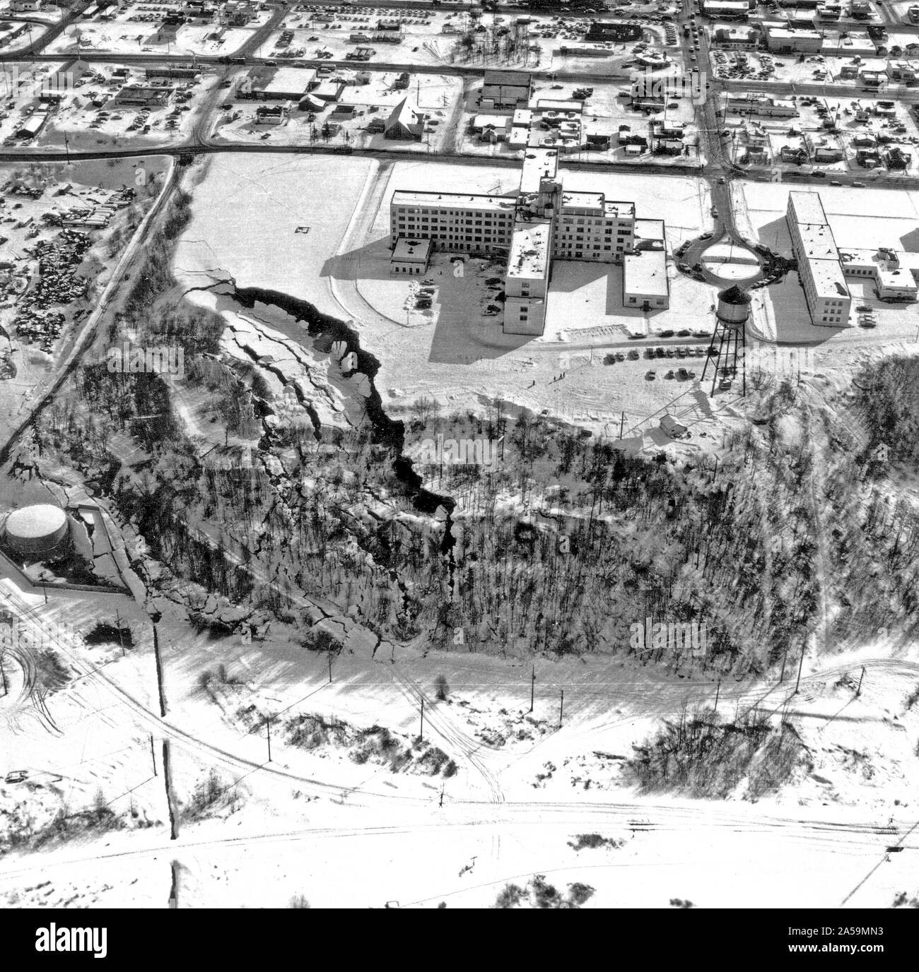 March 27, 1964 Alaska earthquake. The landslide occurred next to this hospital in Anchorage which is showing graben and pressure ridges. Stock Photo