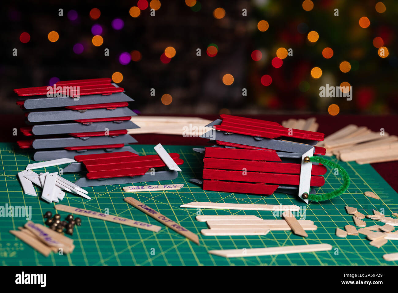 A crafter’s workspace full of cut craft sticks and partially finished