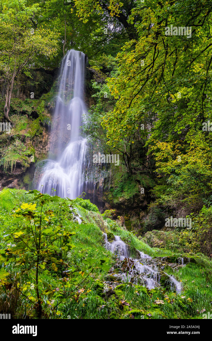 Germany, Amazing tall 37 meters high waterfall of  bad urach in climatic spa region of swabian alb nature landscape hidden in green jungle like forest Stock Photo