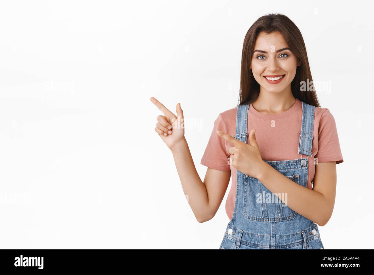 Modern good-lookin confident, assertive woman pointing upper left corner and smiling camera, recommend use promo coupon or suggest good choice for Stock Photo