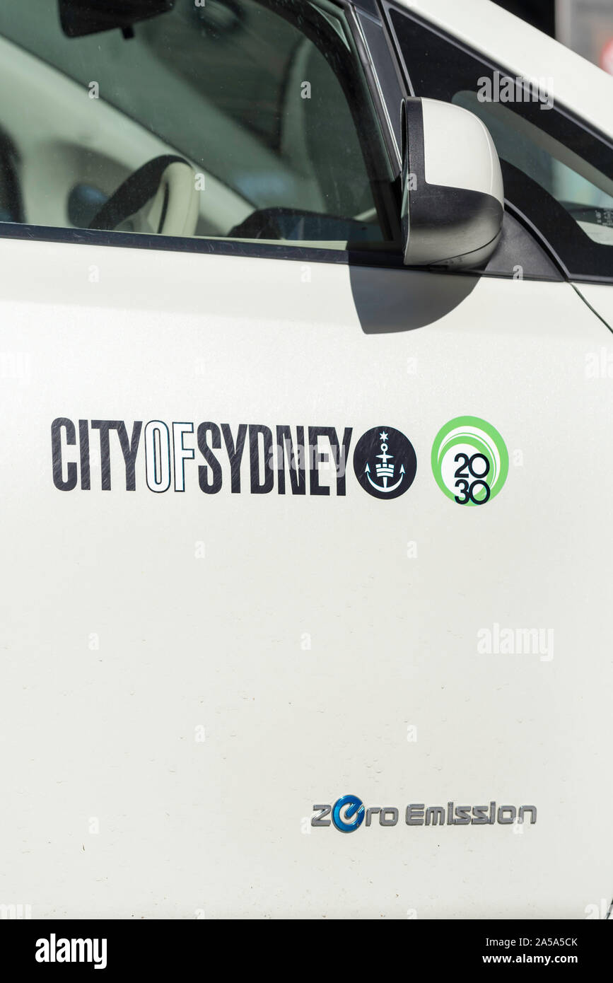 On a sunny day the drivers side door of a zero emissions Nissan, City of Sydney Council motor vehicle displaying the city's logo. Stock Photo