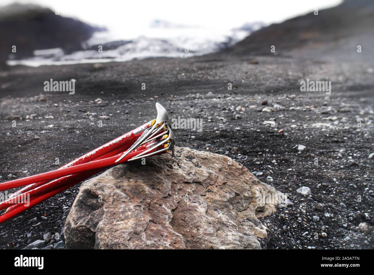 Climbing axes on a rock on Myrdalsjökull, a glacier on top of the Katla volcano in Iceland. The dark spots are ashes from nearby Eyjafjallajökull. Stock Photo