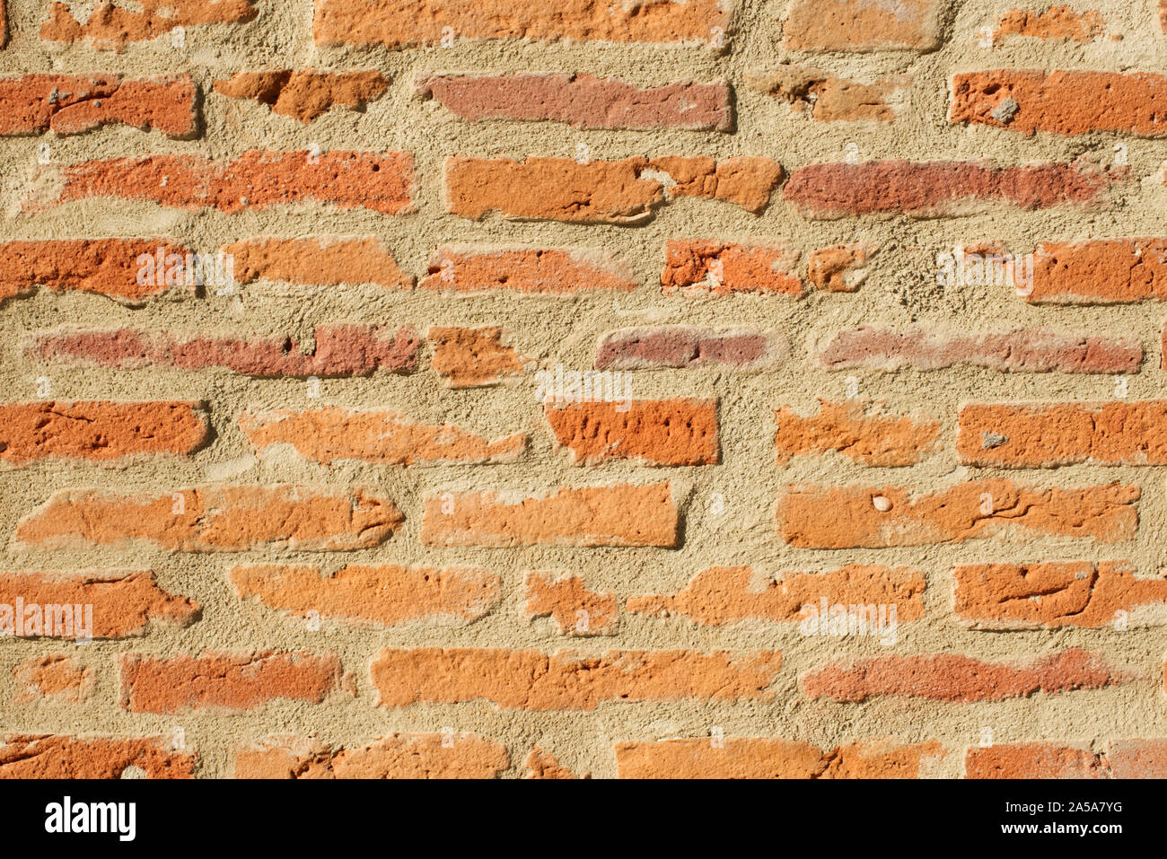 Part of a wall constructed of old, red and orange bricks. Landscape oriented background with a lot of copy space. Stock Photo