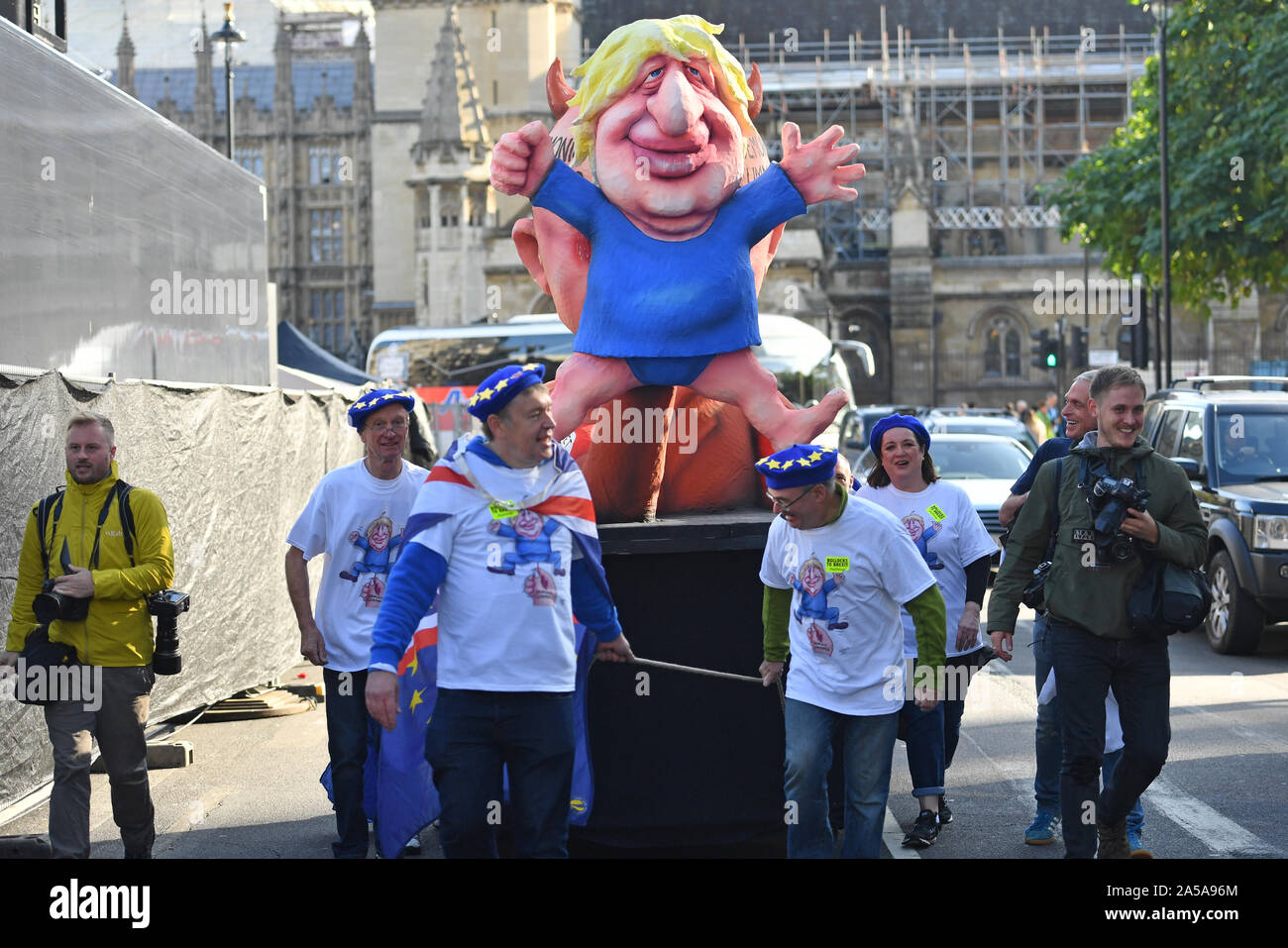 Protesters pull a float depicting Prime Minister Boris Johnson outside the Houses of Parliament in London after he delivered a statement in the House of Commons on his new Brexit deal on what has been dubbed 'Super Saturday'. Stock Photo