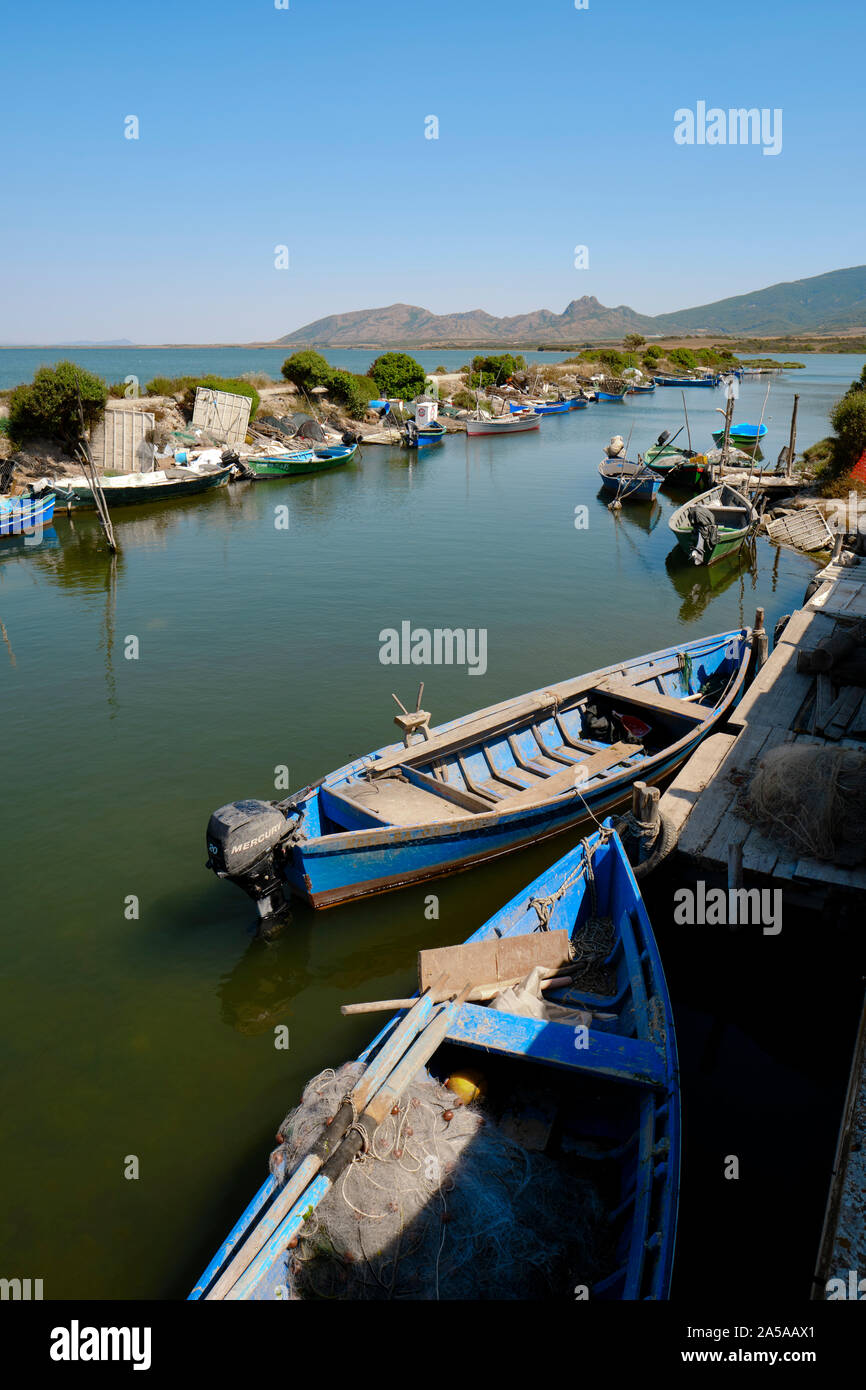 The traditional fishing boats and salt water lagoon of Marceddì / Laguna di Marceddì / Stagno di San Giovanni in Oristano west Sardinia Italy Europe Stock Photo