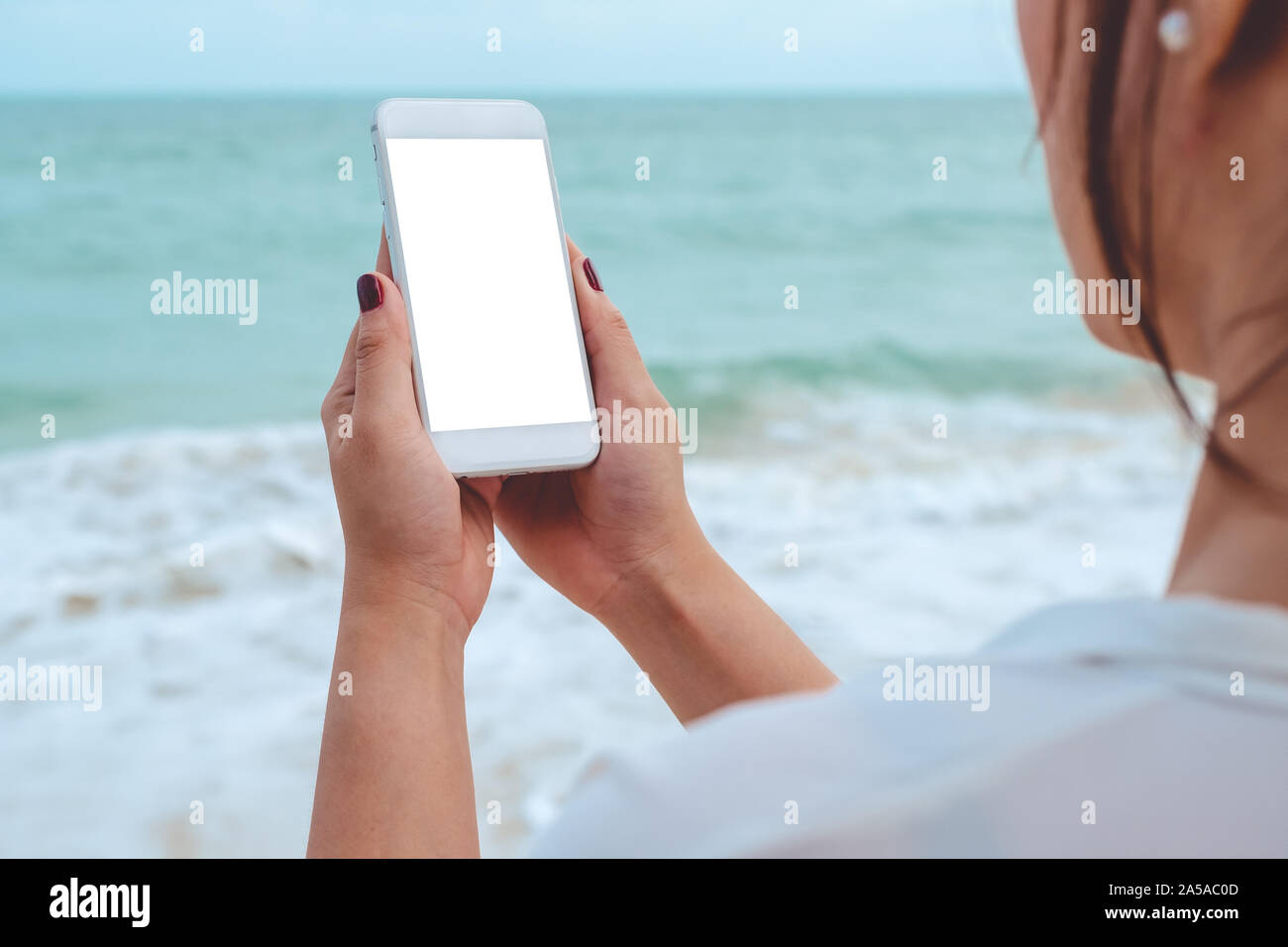 Mockup image of a woman's hand holding white mobile phone with blank ...