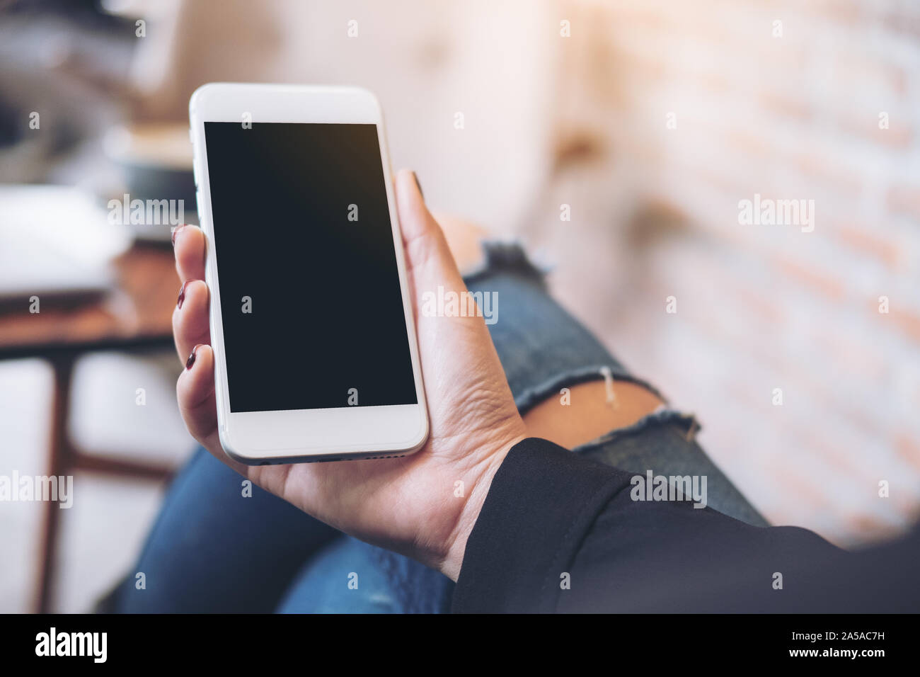 Mockup image of a woman's hand holding white mobile phone with blank ...