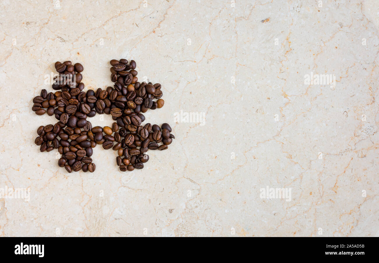 Hash tag icon symbol made from roasted coffee beans on marble surface flat lay image with copy space for text - modern social media icons and symbols. Stock Photo