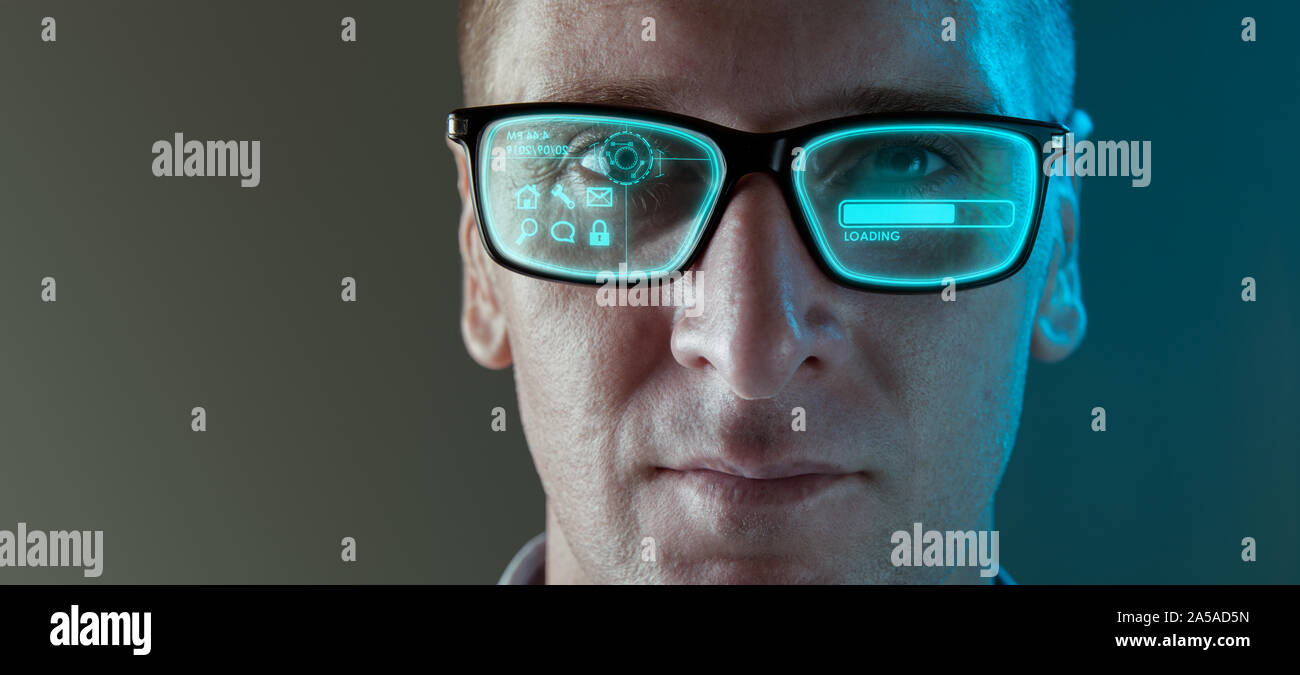 A close up image of a man wearing smart arugmented reality glasses with virtual screen displaying icons and loading screen - modern technology concept Stock Photo