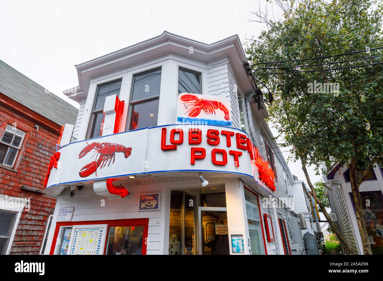 Cedar shingled frontage and illuminated neon name signs of local seafood restaurant, Lobster Pot, in downtown Provincetown, Cape Cod, New England, USA Stock Photo