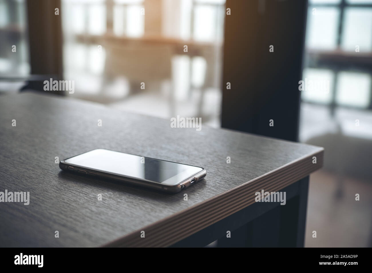 A single mobile phone on wooden table in the office Stock Photo