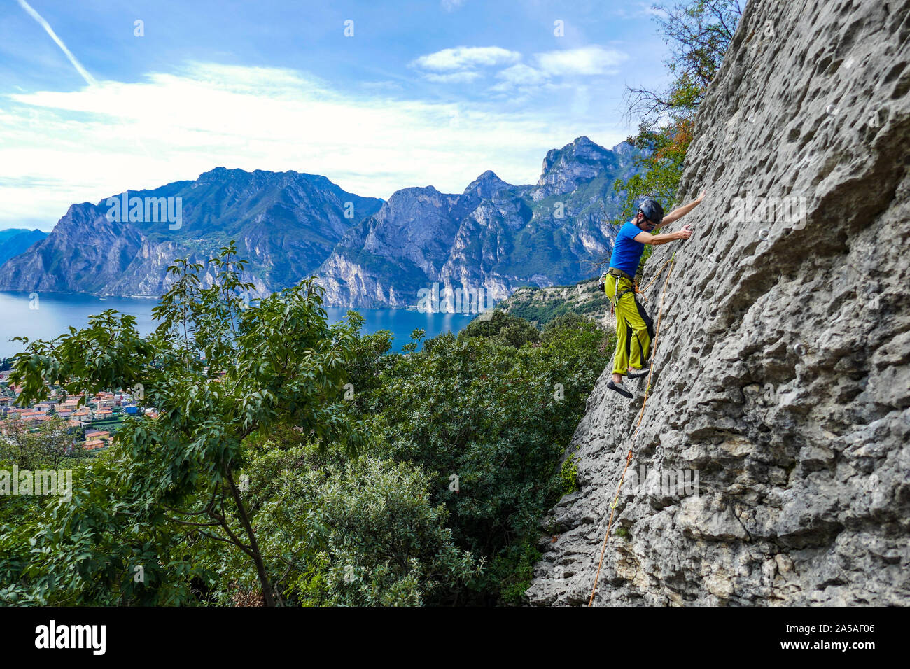 Rock climber in bright colours on Belvedere cliff above Lake Garda, Italy Stock Photo