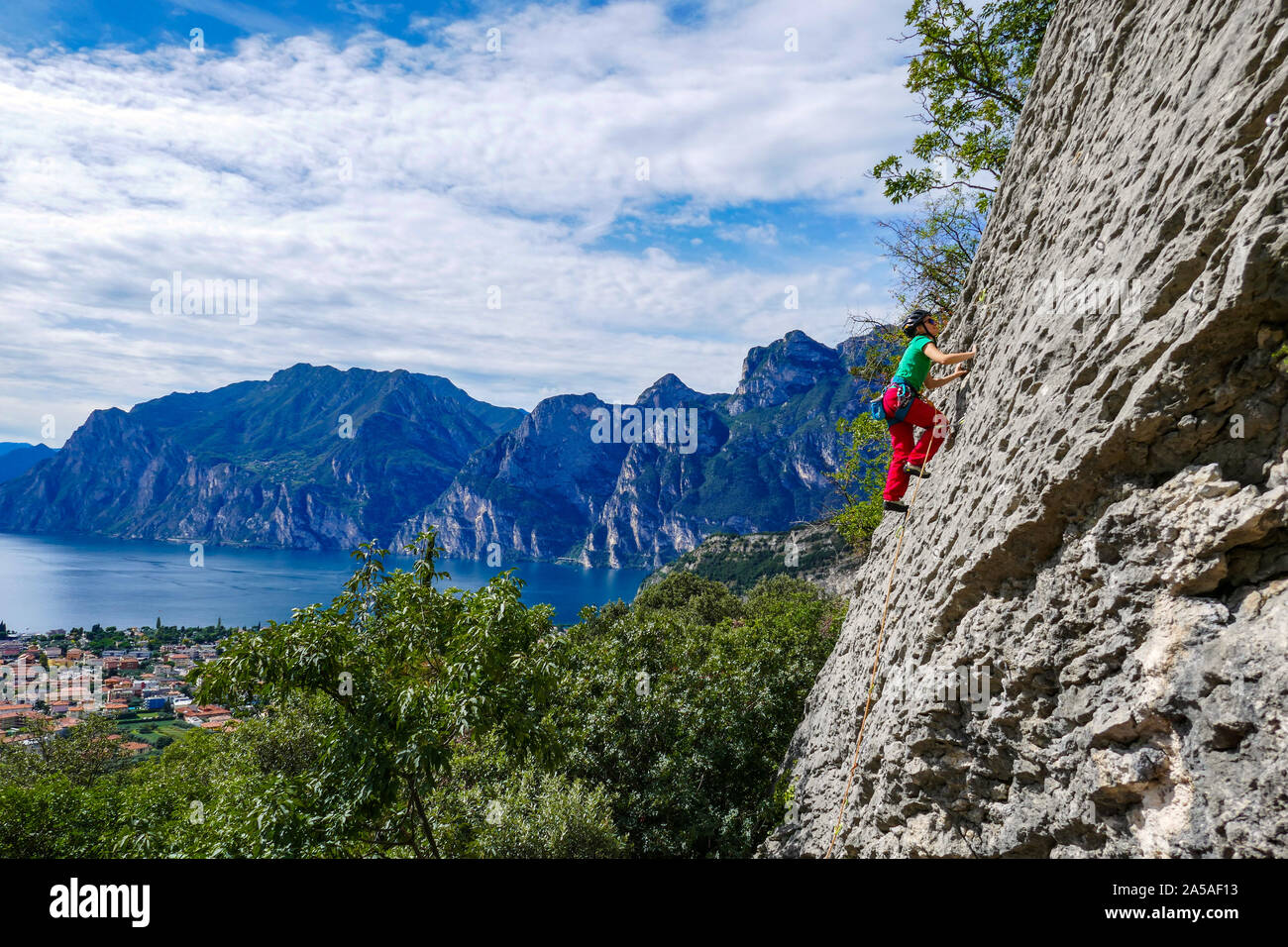 Rock climber in bright colours on Belvedere cliff above Lake Garda, Italy Stock Photo