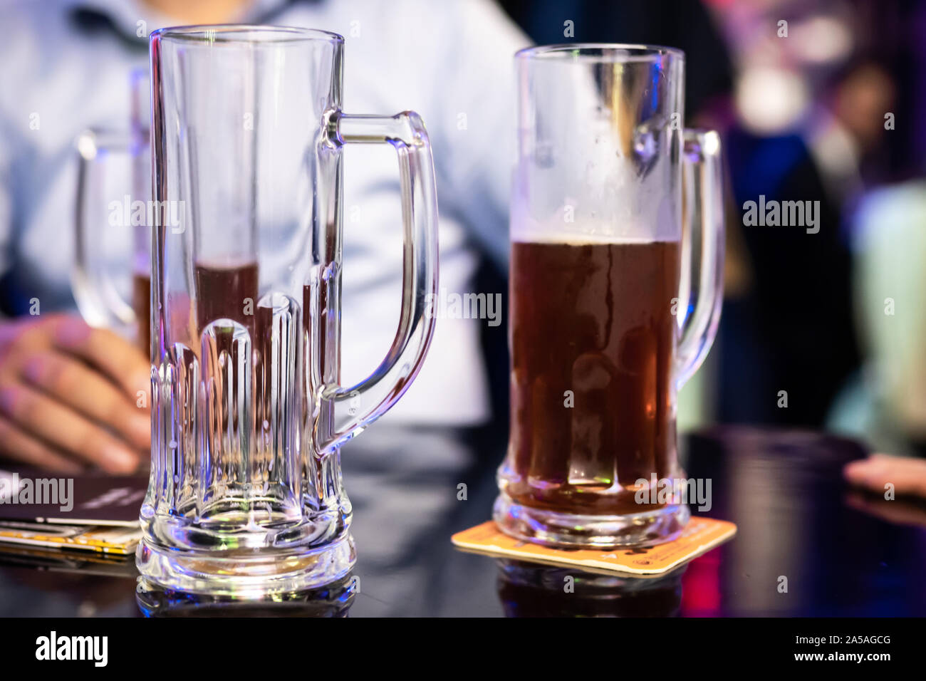 Man sitting at a bar with some of beer pints on the table. Stock Photo