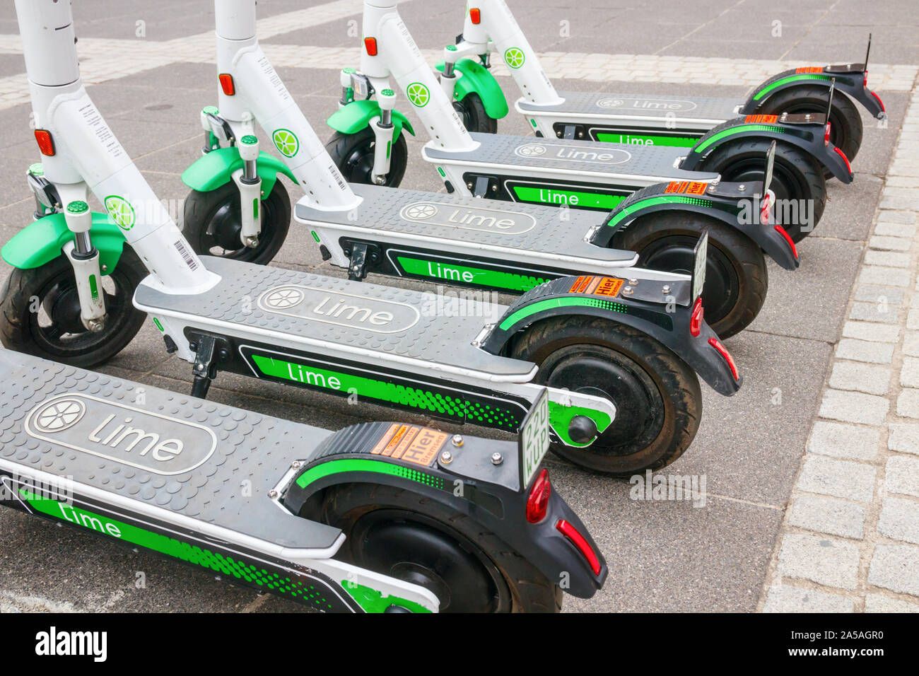 Detail of a row of five model Lime-S electric scooters (E-Scooters) from Lime parked at the sidewalk of a street. Frankfurt am Main, Germany. Stock Photo