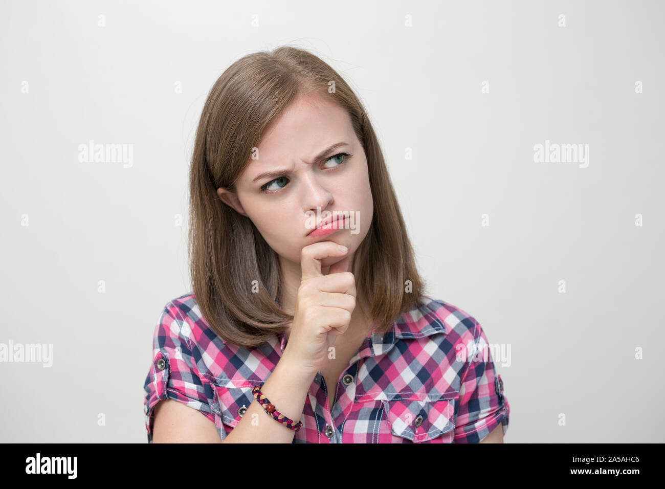 Young caucasian woman girl with questioning, puzzled, confused expression, thinking or remembering something Stock Photo