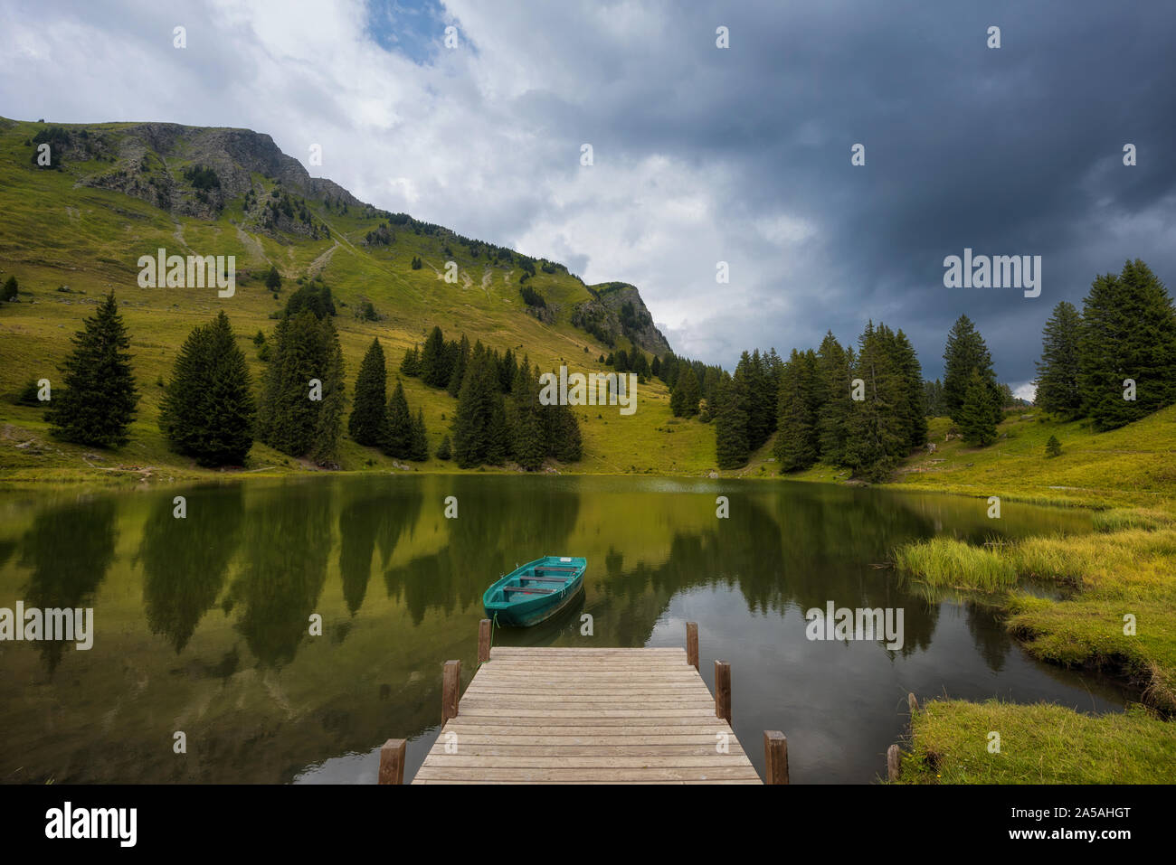 tied rowing boat on Lac Retaud mountain lake with clear water reflections Stock Photo