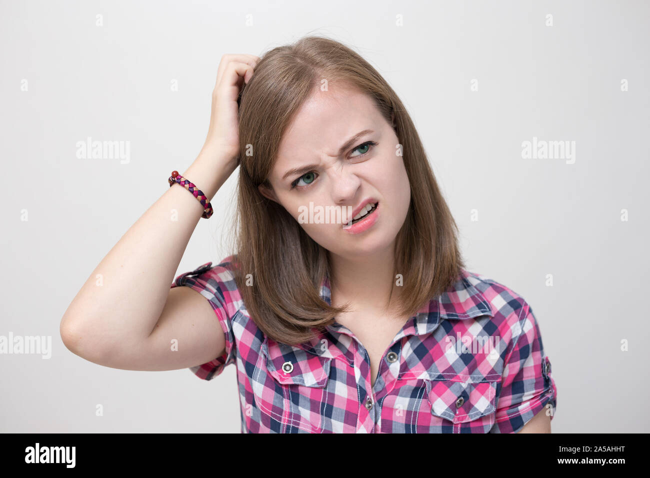 Young caucasian woman girl with questioning, puzzled, confused expression, thinking or remembering something Stock Photo