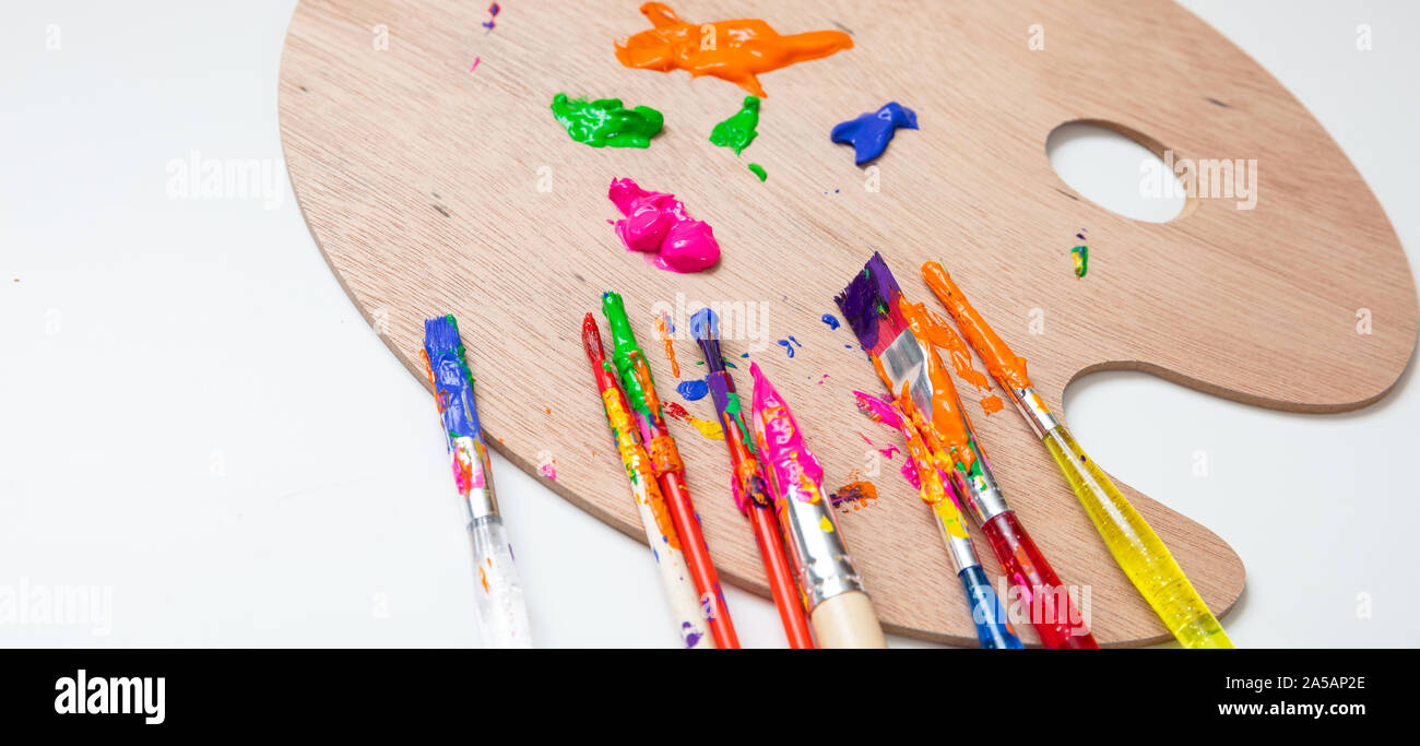 Painting concept. Paintbrushes, colorful paints and wood palette on white color background, copy space Stock Photo