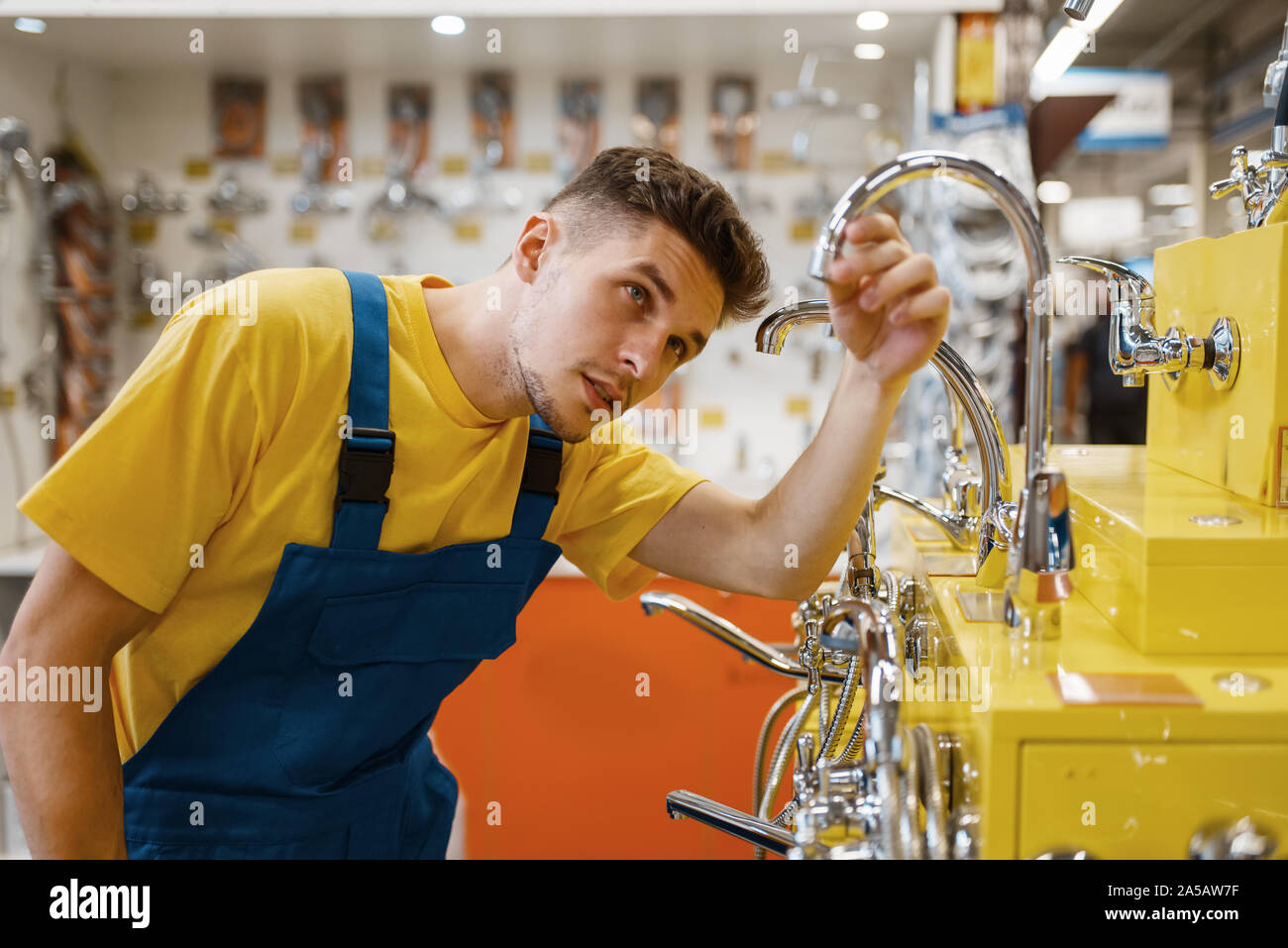 Male builder choosing water tap in hardware store Stock Photo Alamy