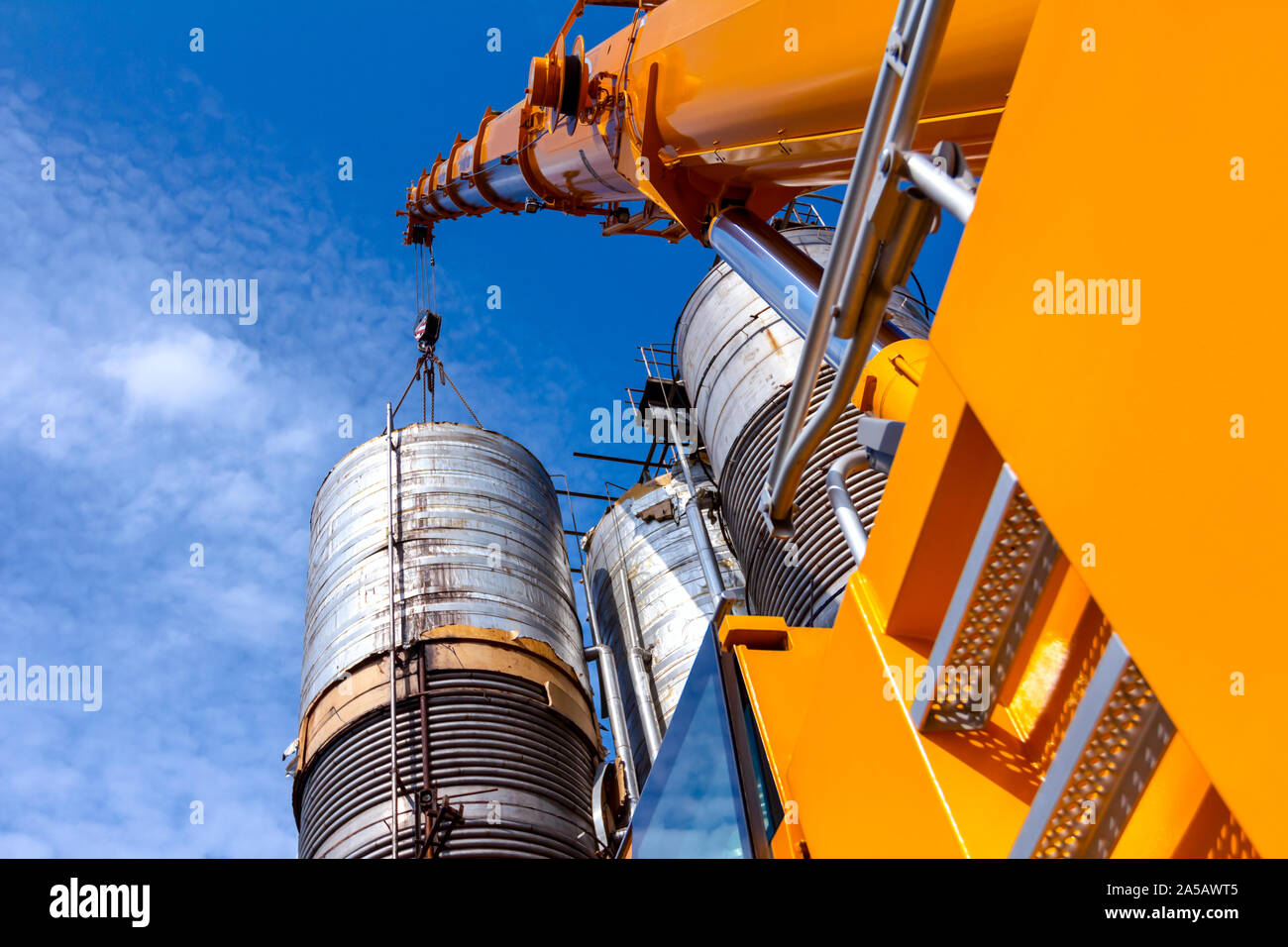 Metal ladders behind cabin on mobile crane with hook and straps is