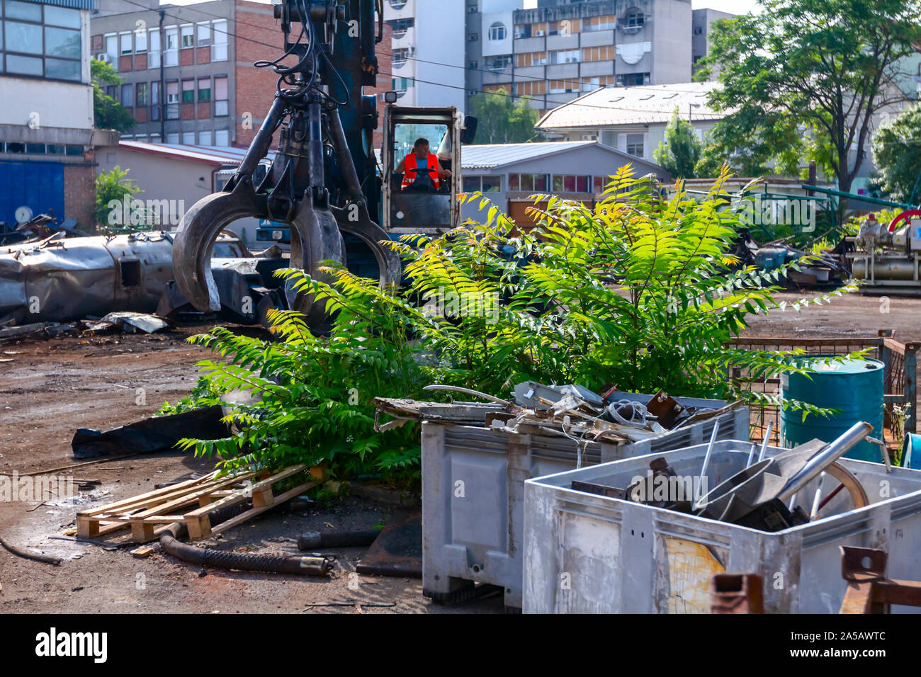 View on machine, loader manipulator with hydraulic grappling claw until is collecting, moving old steel, scrap metal. Stock Photo